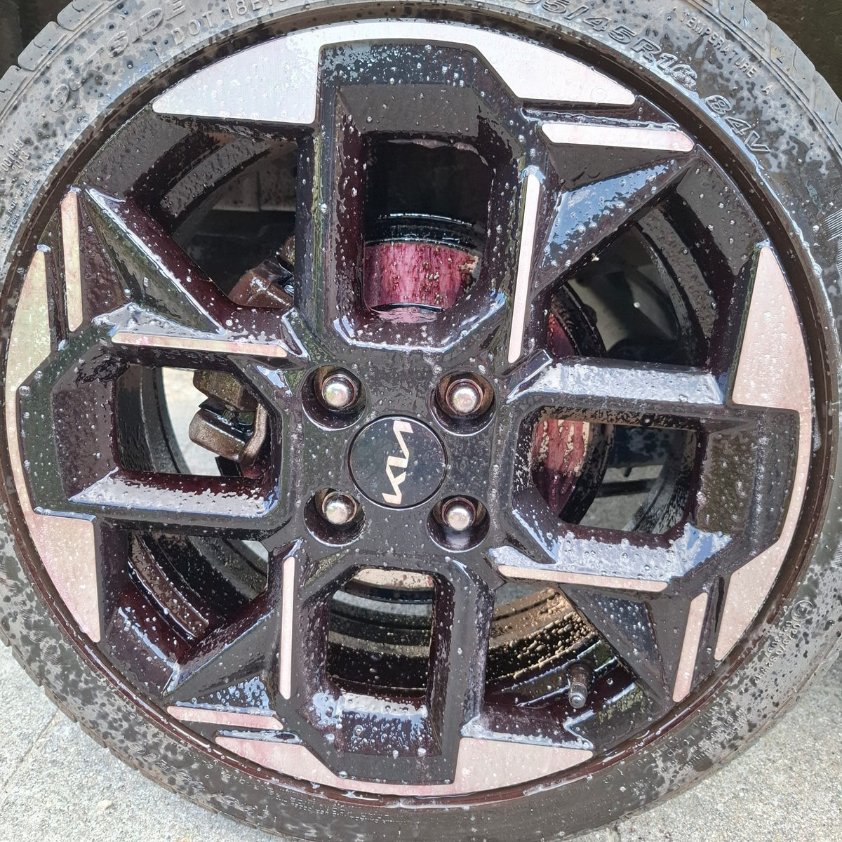 Kia-velg met reinigingsschuim tijdens het reinigen van velgen